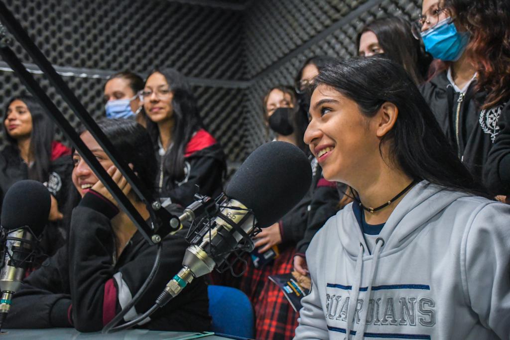 Estudiantes realizan pruebas en el estudio de radio. En la imagen se ven a varias de ellas como locutoras, mientras sus compañeras las acompañan