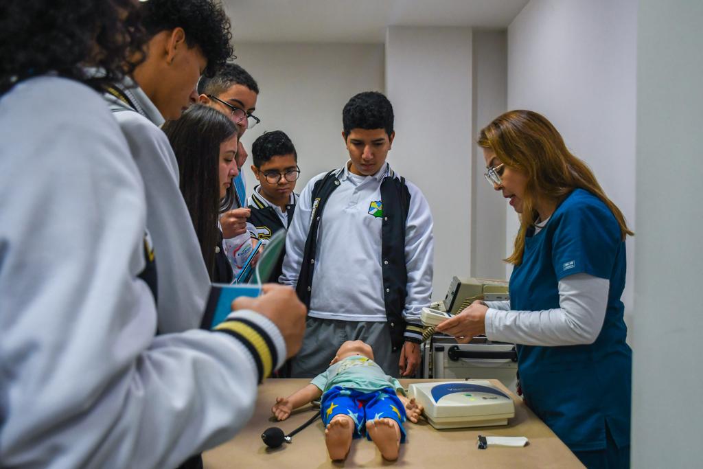 Profesora de Enfermería le explica a estudiantes cómo funcionan los simuladores del programa de Enfermería
